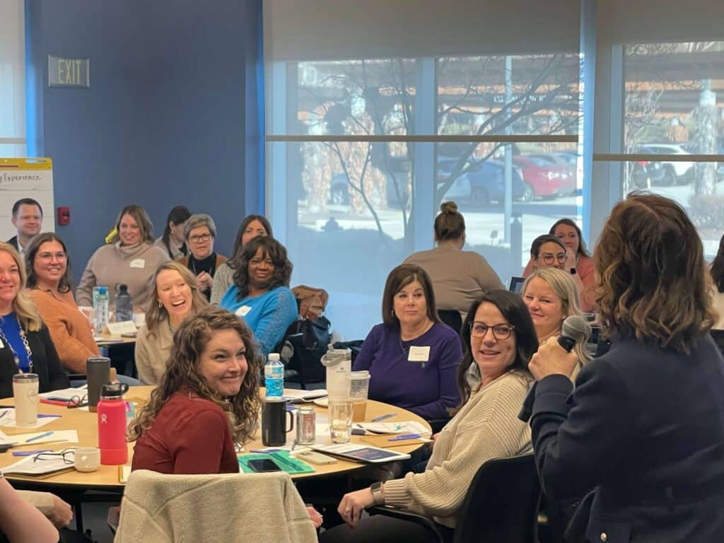 Nurse leaders in a training session, engaged and smiling.