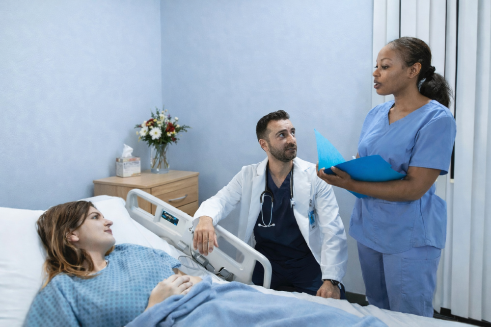 Clinical team discusses next steps with a patient. Nurse leader and team huddling during Patient Safety Awareness Week 2026.